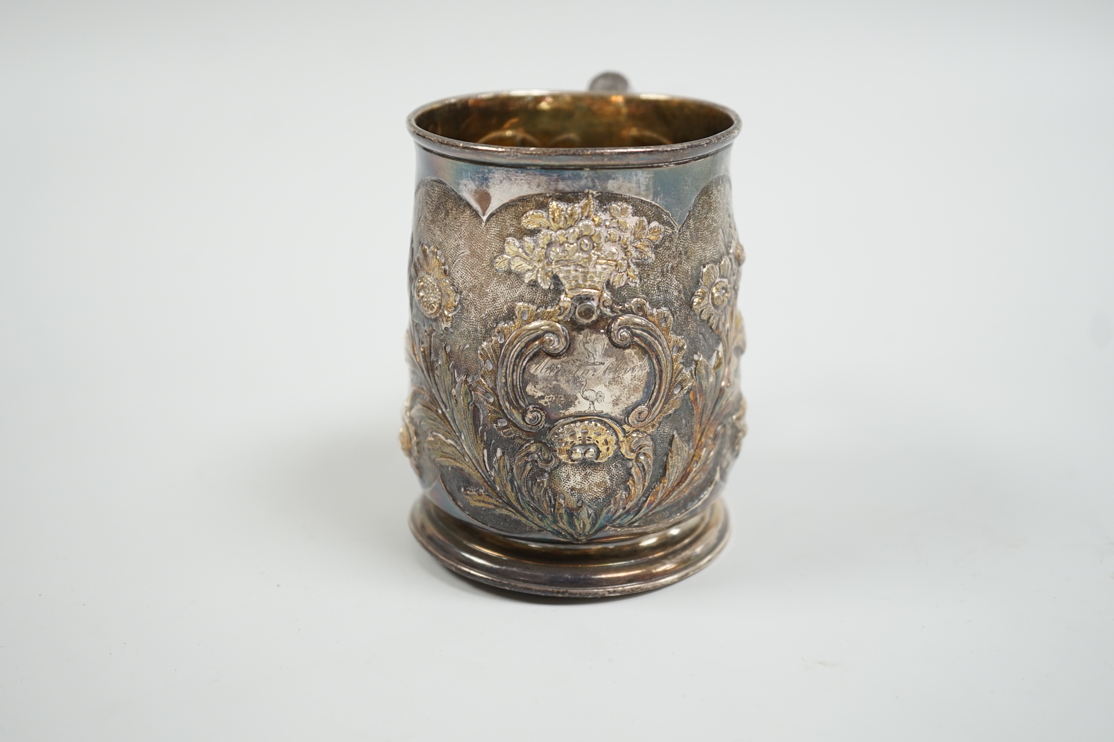 A George II silver mug, with later embossed decoration, makers mark rubbed, London, 1724, 9cm, (a.f.) 6.1oz.